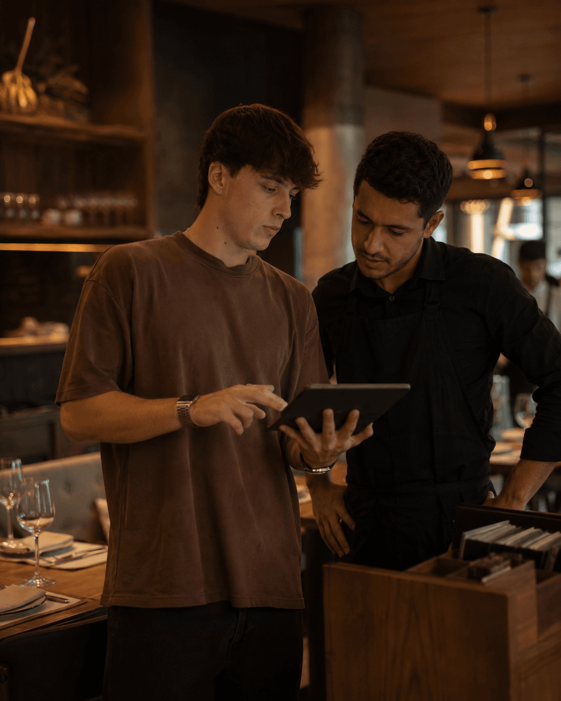 Emiliano Rodriguez Savio mostrando NOMO en la tablet en un restaurante